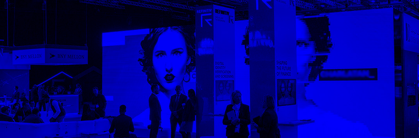 Blue treatment to image of event stand at Sibos with large LED screen displaying images of twins and a number of people standing around in the Refinitiv stand