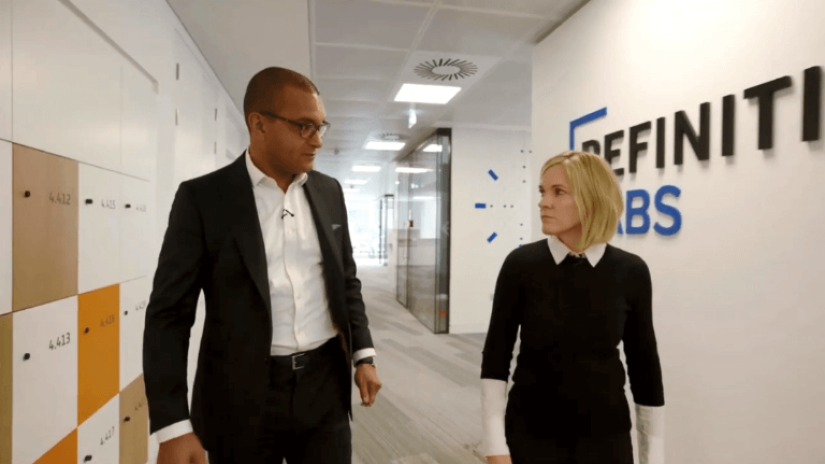 Two Refinitiv employees walking through the company corridors and discussing financial crime
